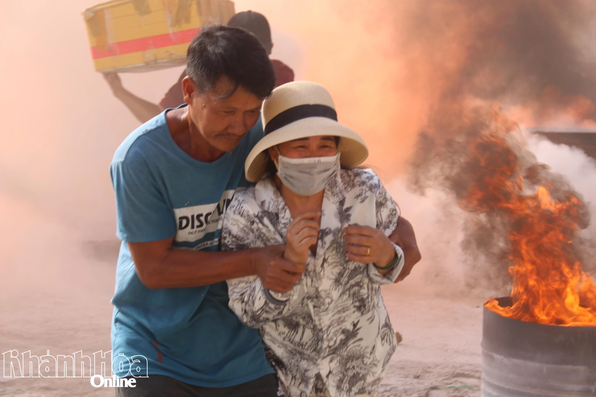 Một người được đưa ra khỏi căn nhà xảy ra cháy đến nơi an toàn.