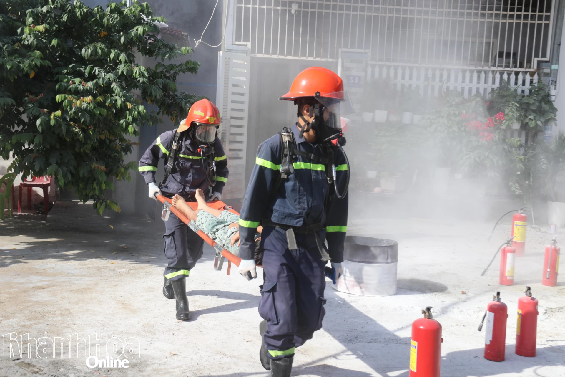 Các chiến sĩ chữa cháy trang bị mặt nạ phòng độc, tiếp cận hiện trường giải cứu một nạn nhân.