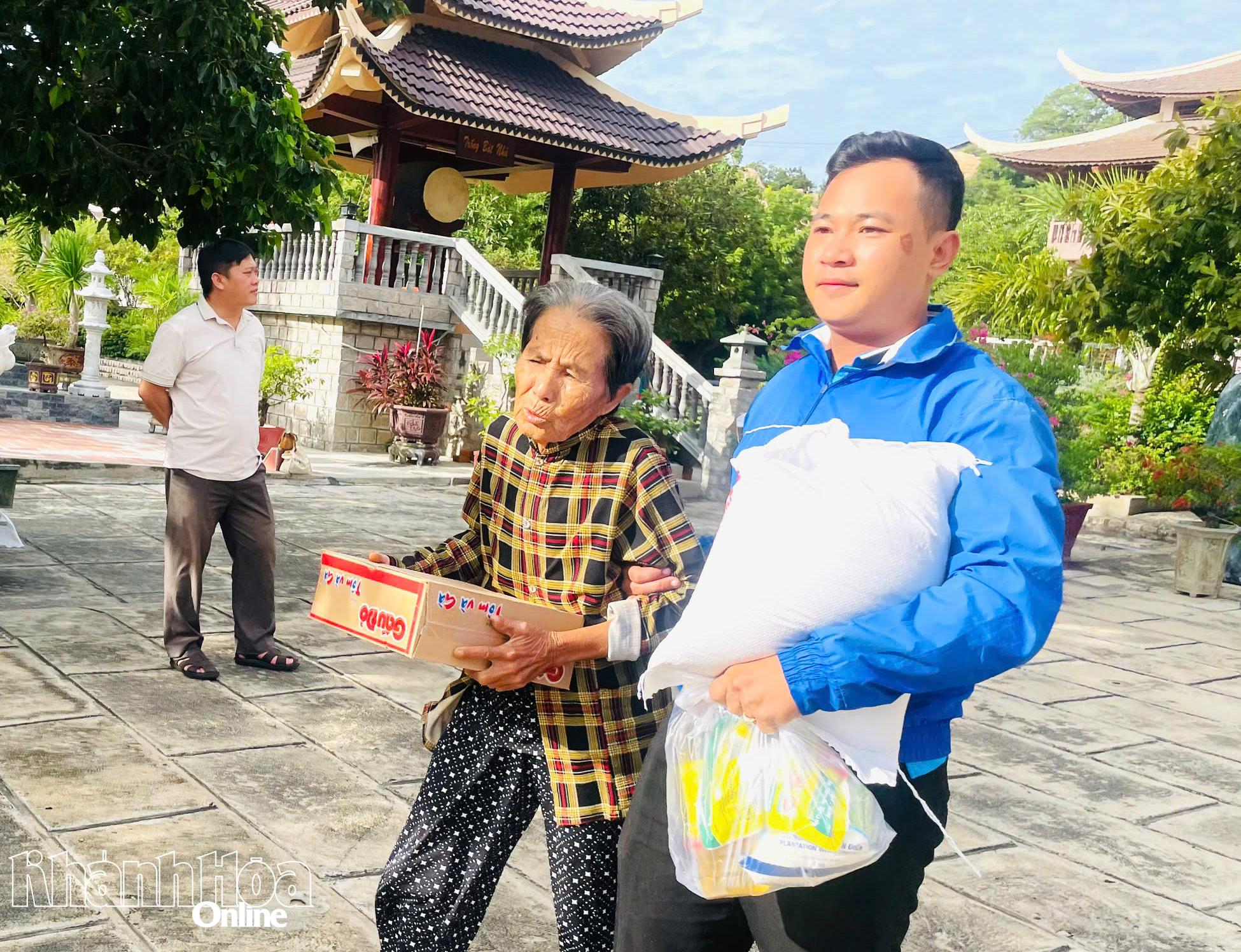 Đoàn phường Ninh Chử hỗ trợ người lớn tuổi mang quà về nhà.