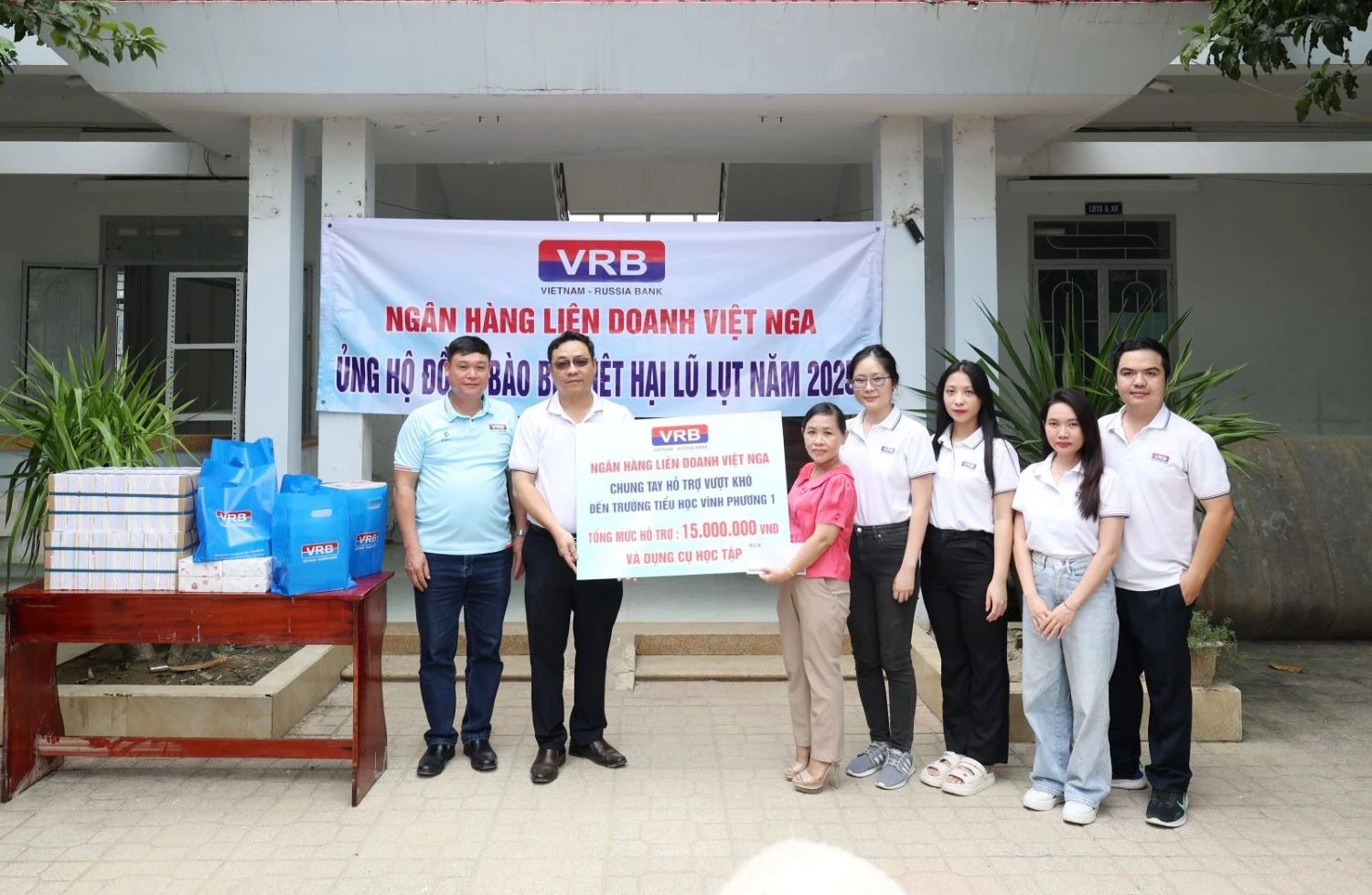 Đại diện Ngân hàng Liên doanh Việt -Nga - Chi nhánh TP. Hồ Chí Minh trao bảng tượng trưng số tiền 15 triệu đồng cho Trường Tiểu học Vĩnh Phương 1.