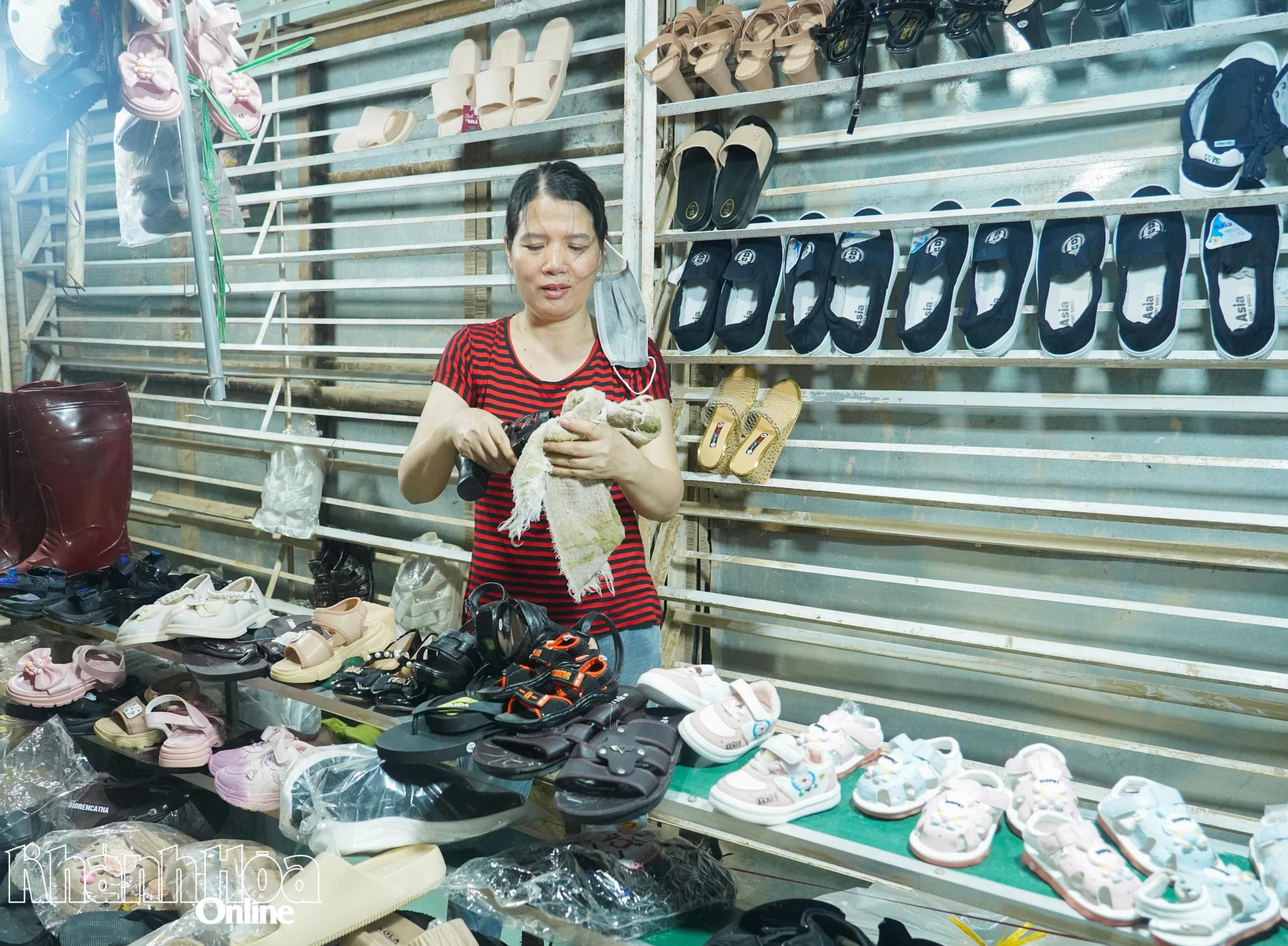 Một tiểu thương tại chợ Ga Vĩnh Thạnh lau dọn hàng sau những ngày bị ngập.