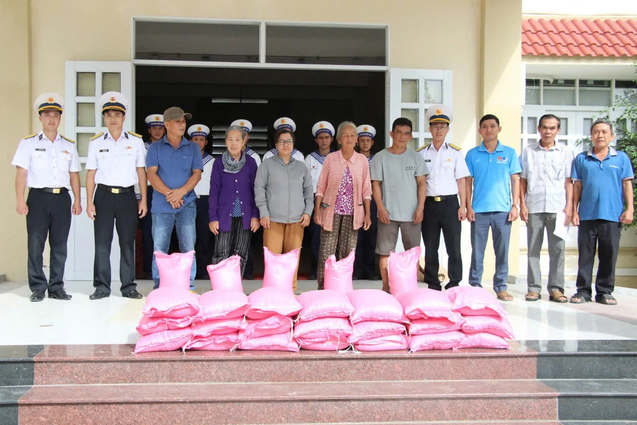 Đại diện lữ đoàn và doanh nghiệp trao quà đến người dân.