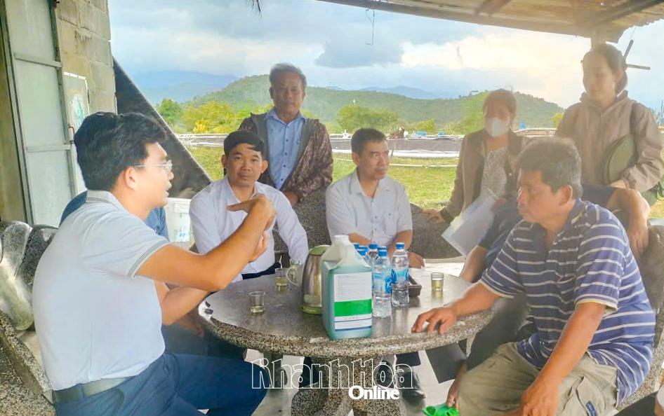 Cán bộ khuyến nông hướng dẫn nông dân xử lý men vi sinh tại vùng nuôi trồng thủy sản xã Vạn Thắng.