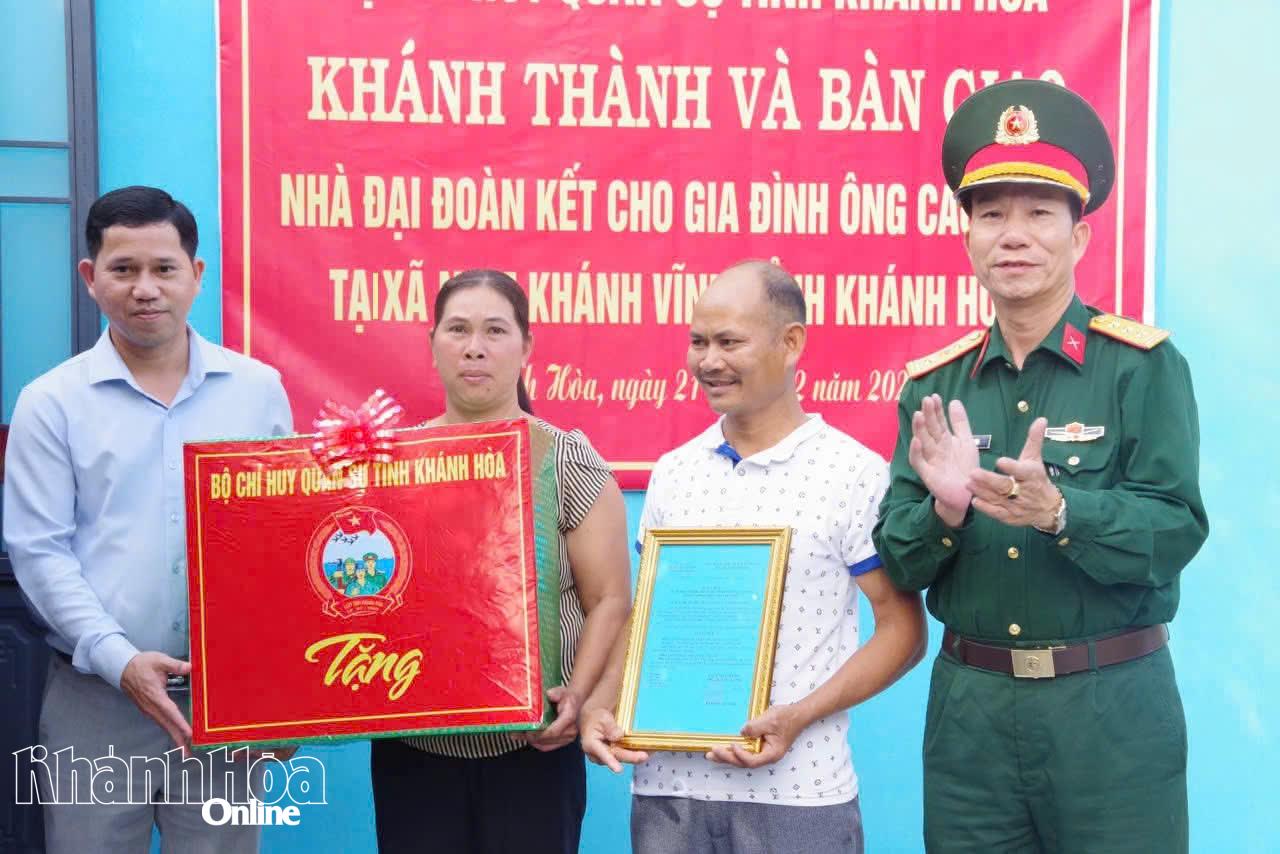 Đại diện Bộ Chỉ huy Quân sự tỉnh và lãnh đạo địa phương trao quyết định bàn giao nhà và tặng quà cho gia đình.