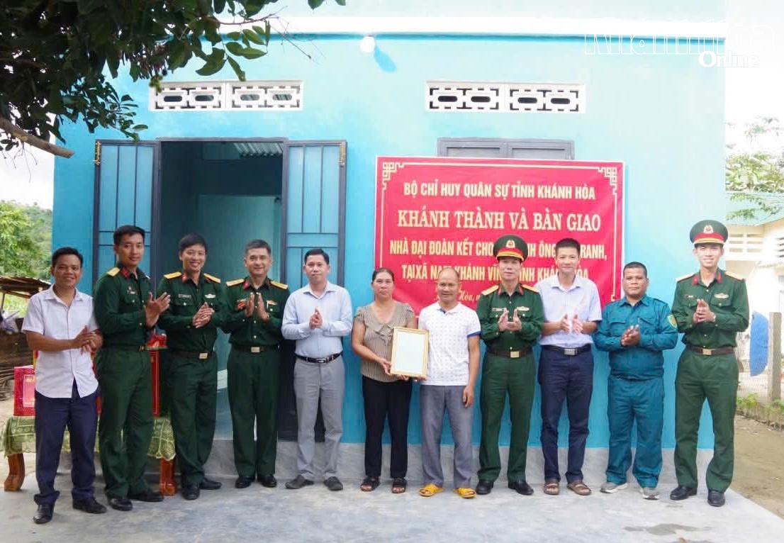 Các đại biểu chụp hình lưu niệm cùng gia đình ông Cam Ranh tại lễ bàn giao nhà.