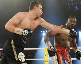 Vitali Klitschko (trái) tung cú đấm mạnh vào mặt Juan Carlos Gomez.