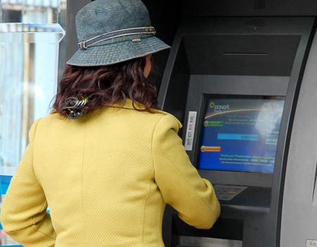 Người lao động rút tiền lương tại máy ATM. Ảnh VnE