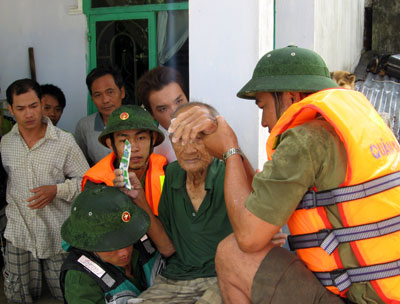 Lực lượng cứu hộ đưa ông Dương Văn Trọng (93 tuổi, tổ 7, thôn Vĩnh Xuân, xã Vĩnh Thái) lên canô an toàn. Ảnh Thành Long