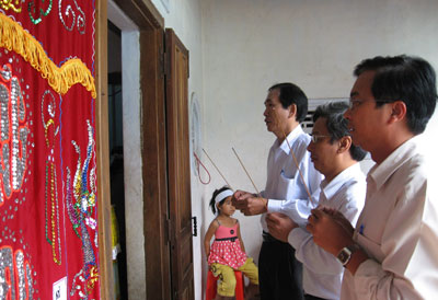 Ông Lê Xuân Thân (giữa) đến thăm, động viên và thắp nhang một gia đình nạn nhân Nguyễn Ngọc Tâm (thôn Đồng Cau, xã Suối Tân, huyện Cam Lâm)