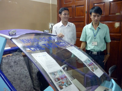 Hai thành viên nhóm nghiên cứu và mô hình xe hybrid chạy xăng- điện. (Ảnh: P. T)&nbsp;