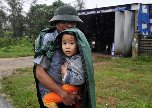 Trẻ em vùng lũ di tản cùng người thân. Ảnh: VnExpress