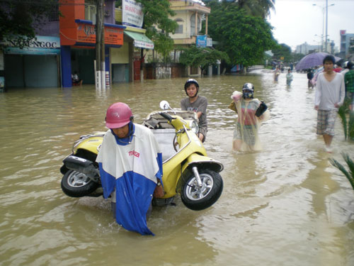 xich-lo.jpgDịch vụ xích lô chở xe máy qua khu vực ngập nước đường 23-10 đắt khách với giá hơn 20 ngàn đồng/xe. (Ảnh: GIANG HÙNG)