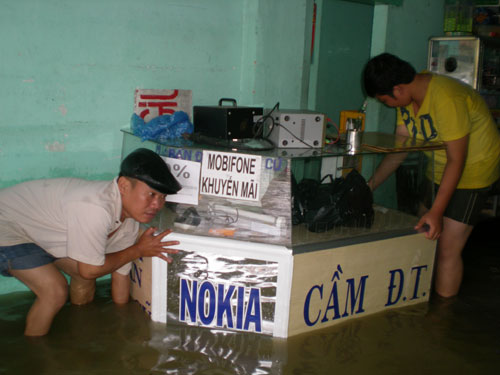 Một gia đình ở Nha Trang thu dọn đồ đạc lên cao tránh nước ngập. (Ảnh: GIANG HÙNG)