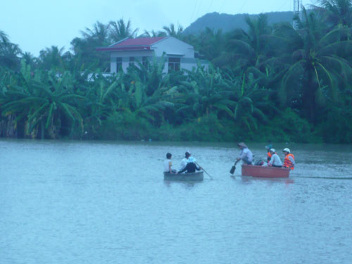 Người dân thôn Mỹ Thanh (Cam Lập, Cam Ranh) di chuyển bằng thúng chai và xuồng cứu hộ đến vùng cao. (Ảnh: NHƯ HƯƠNG)