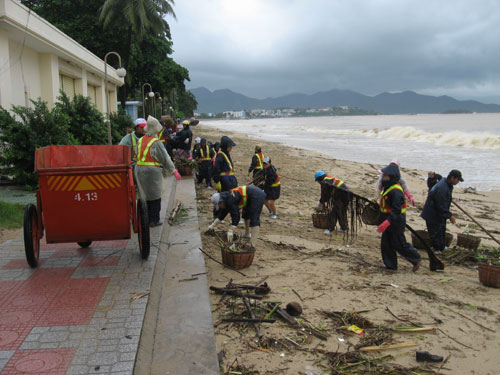 Công nhân Công ty Môi trường đô thị Nha Trang nỗ lực thu gom rác trên bãi biển. 