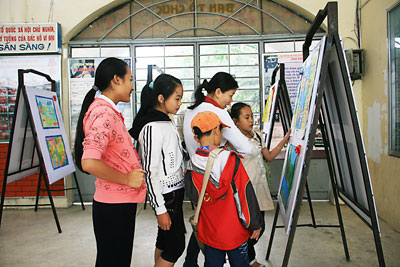 Phụ huynh và học sinh xem tranh đạt giải trưng bày tại Nhà Thiếu nhi tỉnh.