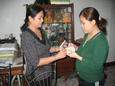 Chị Mai (bên trái) hướng dẫn cho một phụ nữ trong tổ dân phố 7 cách sử dụng thuốc ngừa thai.