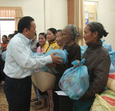 Ông Lê Hữu Hoàng - Tổng Giám đốc Công ty TNHH Nhà nước một thành viên Yến sào Khánh Hòa trao quà cho các hộ dân phường Vĩnh Nguyên.