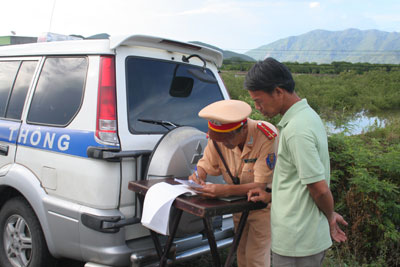 Lực lượng Cảnh sát giao thông lập biên bản xử phạt lái xe vi phạm trạt tự an toàn giao thông trên tuyến Quốc lộ 1A.