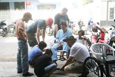 Các thành viên Hội Xe lăn quốc tế trao xe lăn cho người khuyết tật.