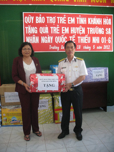  Đại diện lãnh đạo huyện đảo Trường Sa (bên phải) nhận quà cho các em thiếu nhi ngoài đảo.