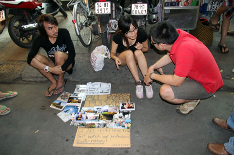 Hai bạn trẻ người Hong Kong bị cướp giật túi ở TP HCM, phải bán bưu ảnh kiếm tiền trên đường phố. Ảnh: PV.