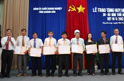 Đồng chí Ngô Hữu Giác - Bí thư Đảng ủy Khối Doanh nghiệp (trái) trao Huy hiệu 30 tuổi Đảng cho các đảng viên.
