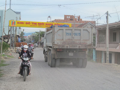 Ảnh: Bụi bốc lên mù mịt khi xe tải đi qua là nguyên nhân người dân bức xúc. (2013) 