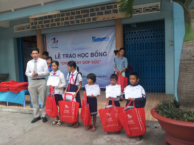 Lãnh đạo Công ty TNHH Tin học TH Nha Trang trao học bổng cho các em học sinh.