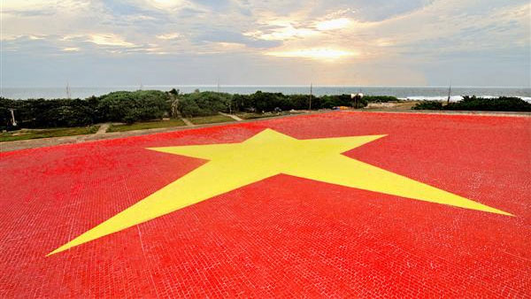 Từ trên không trung (từ vệ tinh, Google Earth hay máy bay) mọi người đều có thể nhìn thấy lá cờ đỏ sao vàng tại đảo Trường Sa Lớn, huyện đảo Trường Sa, tỉnh Khánh Hòa.