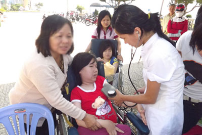  Mẹ con bà Nguyễn Thị Thẩm trong một lần tham gia chương trình khám bệnh từ thiện của các tổ chức xã hội.