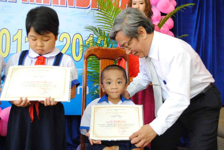 Ông Lê Xuân Thân trao học bổng cho em Trương Hoàng Thiện, học sinh Trường Tiểu học Vĩnh Nguyên 2 (Nha Trang).