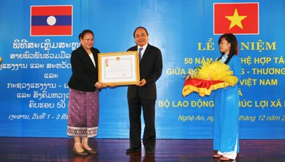 Thay mặt lãnh đạo Đảng và Nhà nước, Phó Thủ tướng Nguyễn Xuân Phúc trao Huân chương Độc lập hạng Nhất của Nhà nước Việt Nam cho Bộ Lao động và Phúc lợi xã hội Lào; trao Huân chương Độc lập hạng Nhì cho Bộ trưởng Onechanh Thammavong. Ảnh: VGP/Lê Sơn