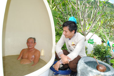 Nhân viên khu du lịch tư vấn cho khách sử dụng dịch vụ tắm bùn.