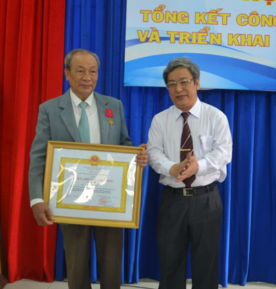 Thừa ủy nhiệm Chủ tịch nước, ông Lê Xuân Thân trao Huân chương Lao động hạng Ba cho ông Bùi Hồng Thái.