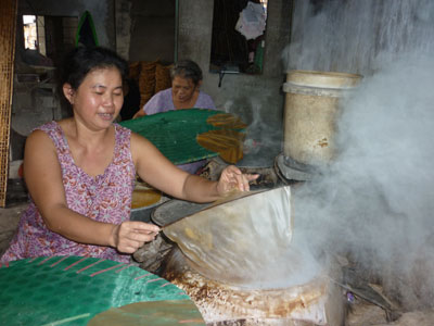 Bà Trần Thị Ngọc Hạnh (trái) bên khung dệt chiếu.