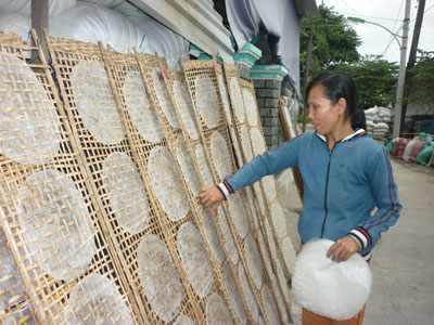 Bà Lê Thị Bưởi mang bánh tráng đi phơi.