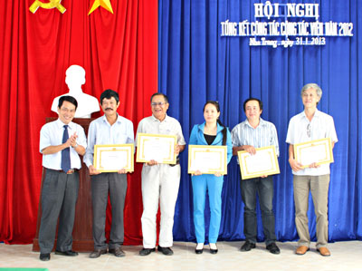 Đồng chí Trần Duy Hưng - Tổng Biên tập Báo Khánh Hòa (bìa trái) khen thưởng các cộng tác viên.