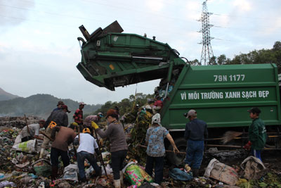 Đứng chờ xe đổ rác để lượm lấy những thứ bán được, dùng được.