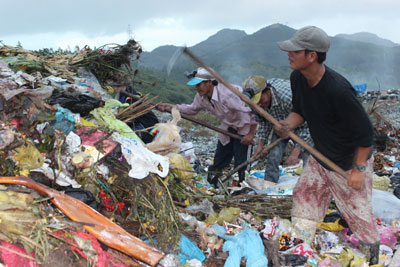 Nhanh tay cào rác để nhặt phế liệu.