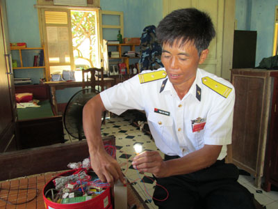Thiếu tá Trịnh Văn Chương giới thiệu về sản phẩm chiếu sáng do anh tận dụng từ những bóng điện đã hỏng.