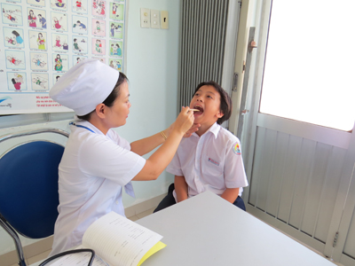   Bác sĩ Trạm y tế Cam Lộc khám răng cho học sinh. 
