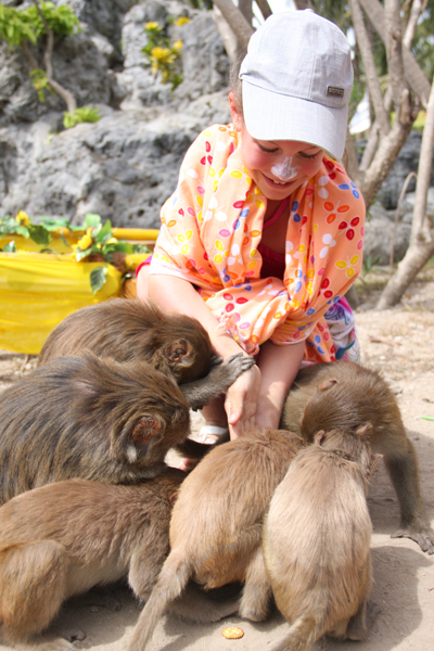 Bé gái người Nga chơi với các chú khỉ trên đảo.