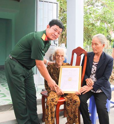 Đại tá Lê Văn Bình, Chỉ huy trưởng Bộ Chỉ huy Quân sự tỉnh trao quyết định tặng nhà tình nghĩa cho gia đình bà Nguyễn Thị Lường.