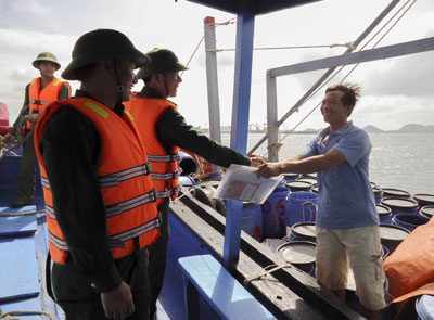 Cán bộ Đồn Biên phòng Cam Ranh kiểm tra công tác đảm bảo an toàn trên tàu của ngư dân trước khi ra khơi.