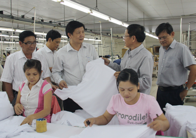 Ông Trần Sơn Hải (đứng giữa) thăm xưởng sản xuất của Công ty TNHH một thành viên Phát triển trang phục phụ nữ kiểu Pháp (Việt Nam).