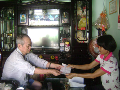 Nhiều người dân phản ánh biên lai thu phí quá mỏng (Trong ảnh: Bà Trương Thị Thúy - Tổ trưởng tổ dân phố Hoàng Diệu trao biên lai cho người nộp phí). 