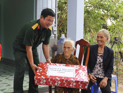  Cán bộ Bộ Chỉ huy Quân sự tỉnh tặng quà cho mẹ Nguyễn Thị Lượng trong ngày  trao nhà tình nghĩa. Ảnh: MẠNH HÙNG