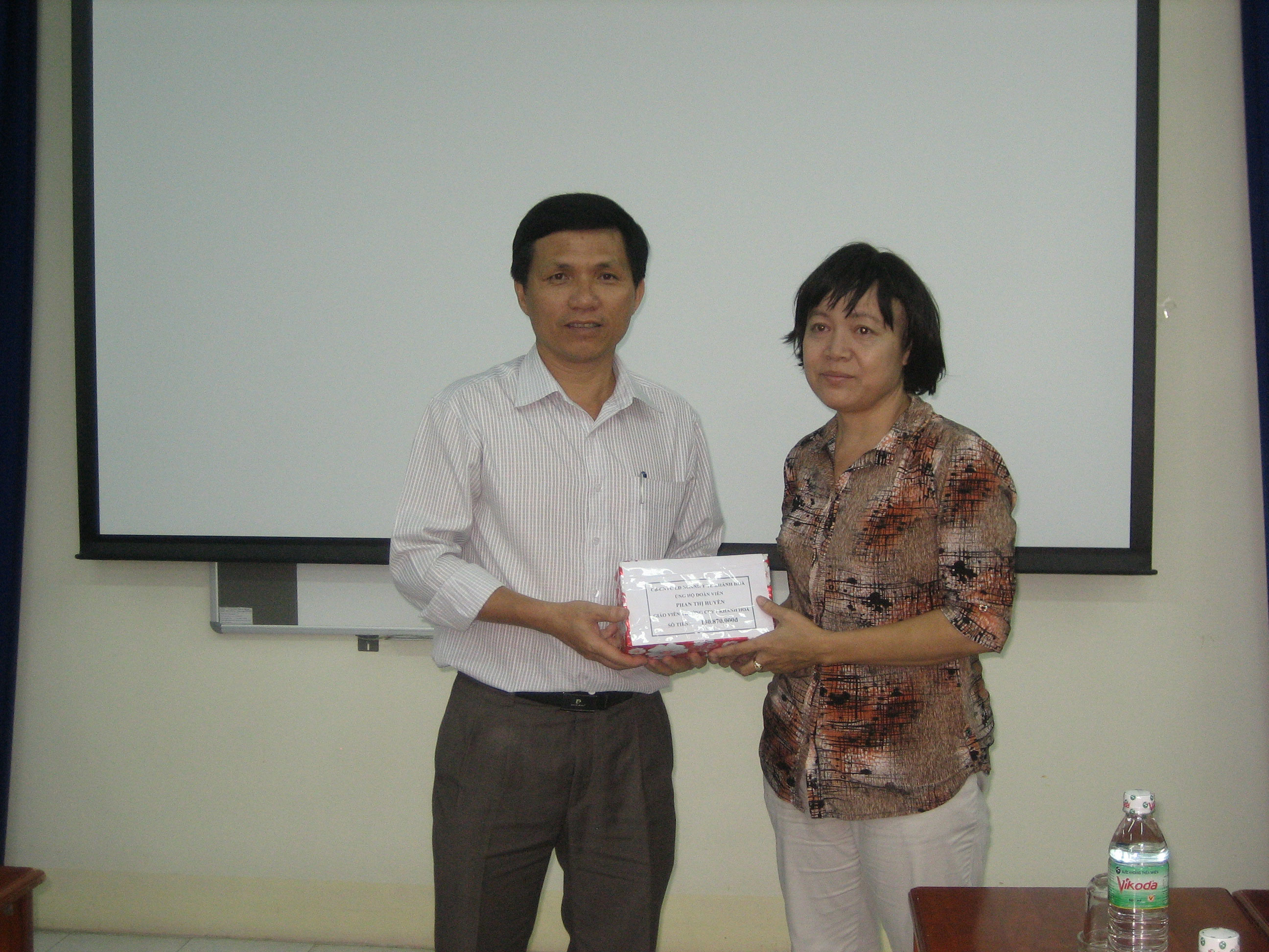 Ông Bùi Xuân Minh - Giám đốc Sở Y tế trao tiền ủng hộ cho cô Huyền.