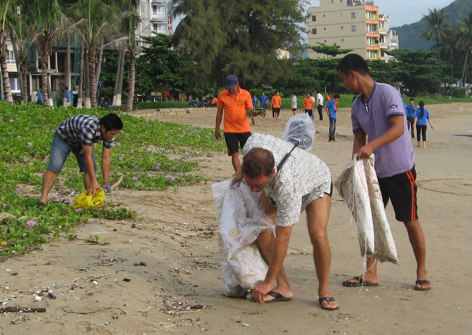 Du khách nước ngoài cùng cán bộ, nhân viên Ban quản lý vịnh Nha Trang thu gom rác. 